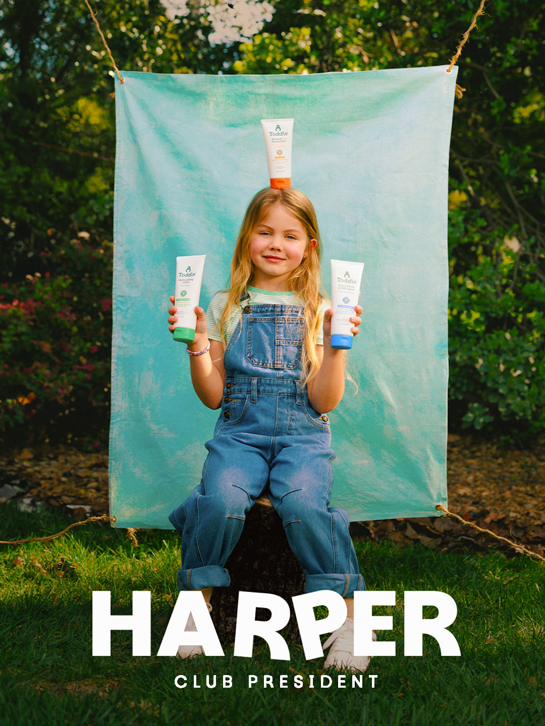 Harper with Toddle Skincare The System — two products in hand, one on her head — complete gentle skincare for kids