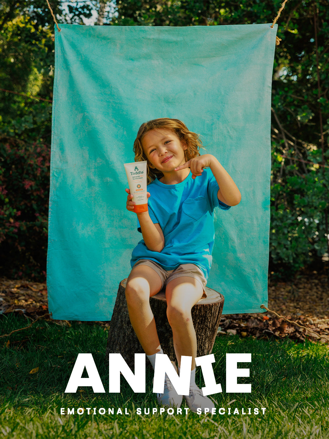 Annie holding Toddle Skincare SPF 50 suncream and pointing at it — safe sun protection for active toddlers